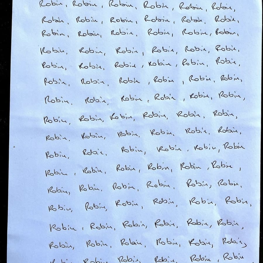 Une feuille couverte du prénom Robin écrit à la main